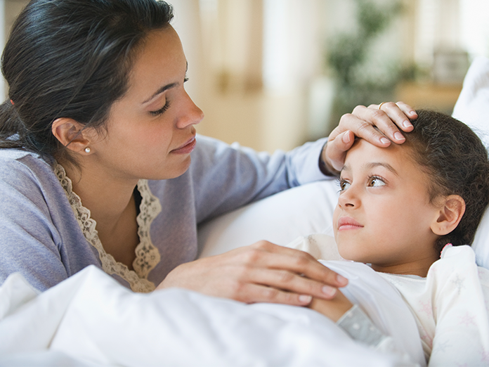 Lady touching sick child's head