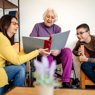 A family, grandchild, mother, and grandmother, together reviewing a binder