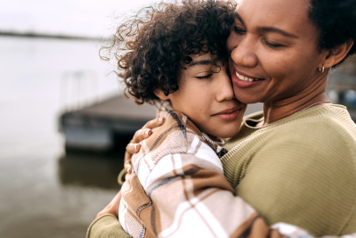 A woman hugging an adolescent child